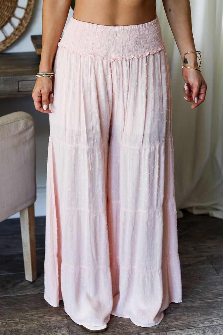 Elevate your wardrobe with our Swiss Swiss Dot Wide leg Pants. These pants feature a soft Swiss Dot pattern with metallic striping, adding a touch of glamour to your look. The smocked waist and tiered wide leg provide both comfort and style. Crafted from 100% Rayon, hand wash for best care. Imported. Bohemian Clothes Boho Pink, Bohemian Clothing Boho Pink, Where To Shop For Modest Clothes, Cute Flowy Pants, Cute Comfy Pants, Modest Pant, Artsy Boho Outfits, Pink Baggy Pants, Tiered Pants