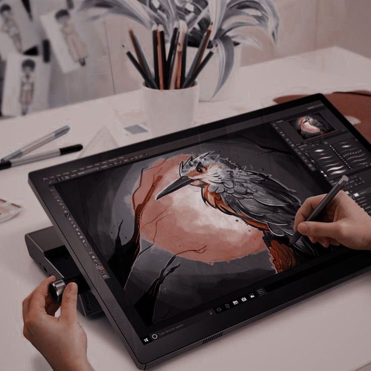 a person is using a tablet to draw a bird on the screen with their hands