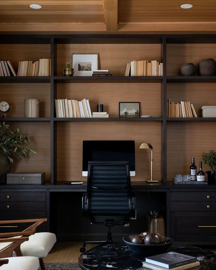 a black chair sitting in front of a computer desk