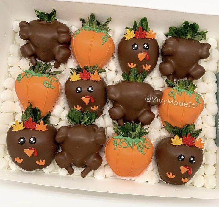 chocolate covered strawberries in the shape of animals and pumpkins with leaves on them