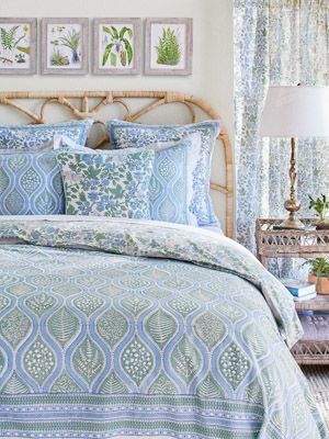 a bed with blue and green bedspread in a bedroom