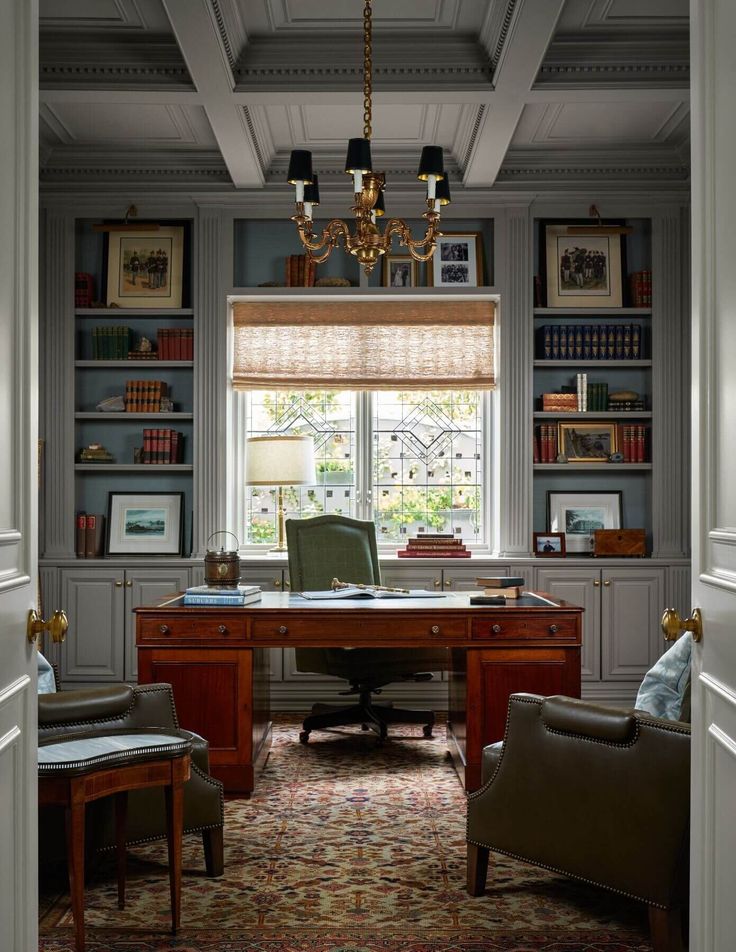 a home office with built in bookshelves, desk and two chairs next to a window