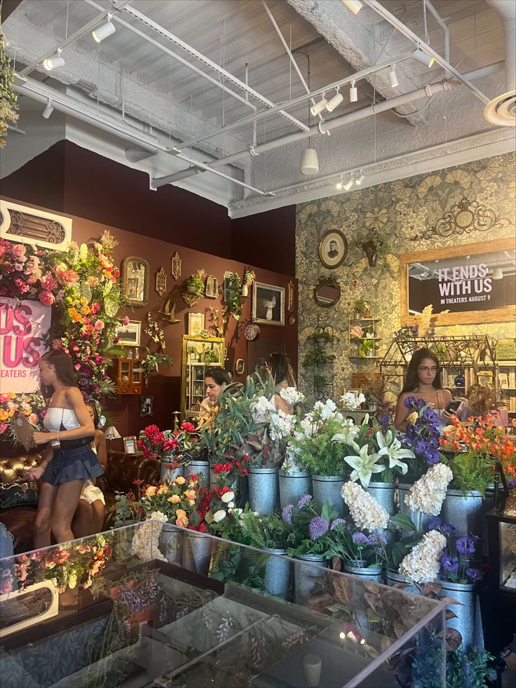 a flower shop filled with lots of different types of flowers and potted plants on display