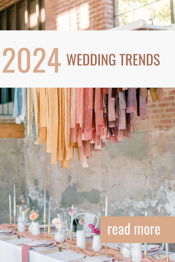 the table is set up for a wedding with pink and orange napkins hanging from it