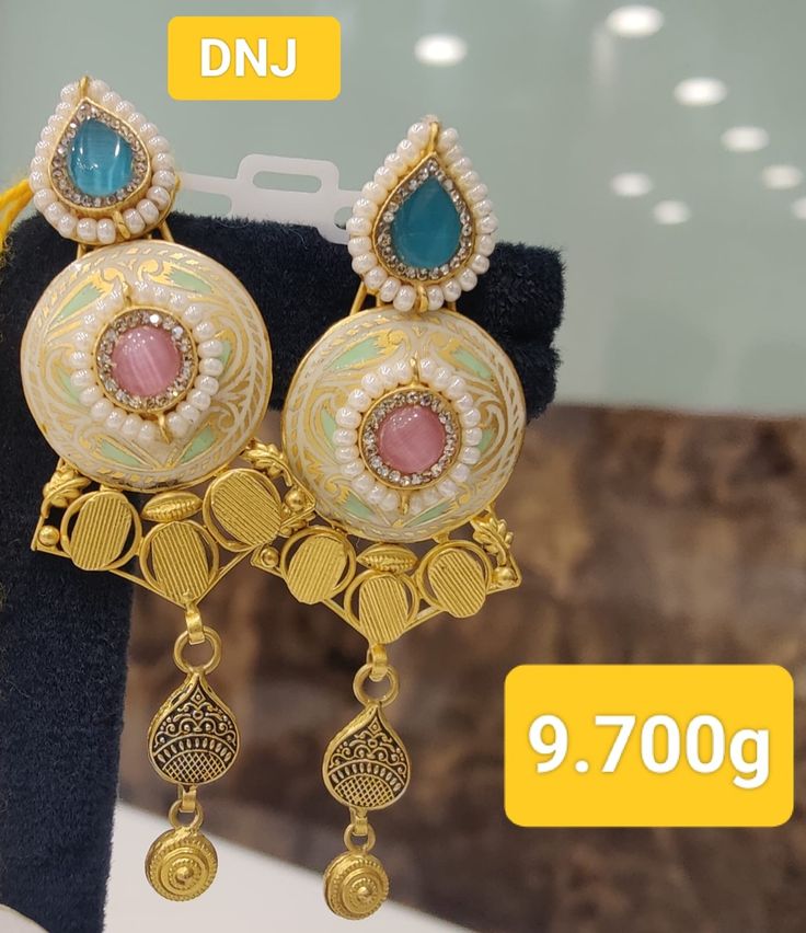 two pairs of earrings are on display for sale