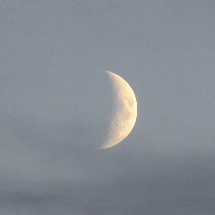 the moon is seen through some clouds on a cloudy day