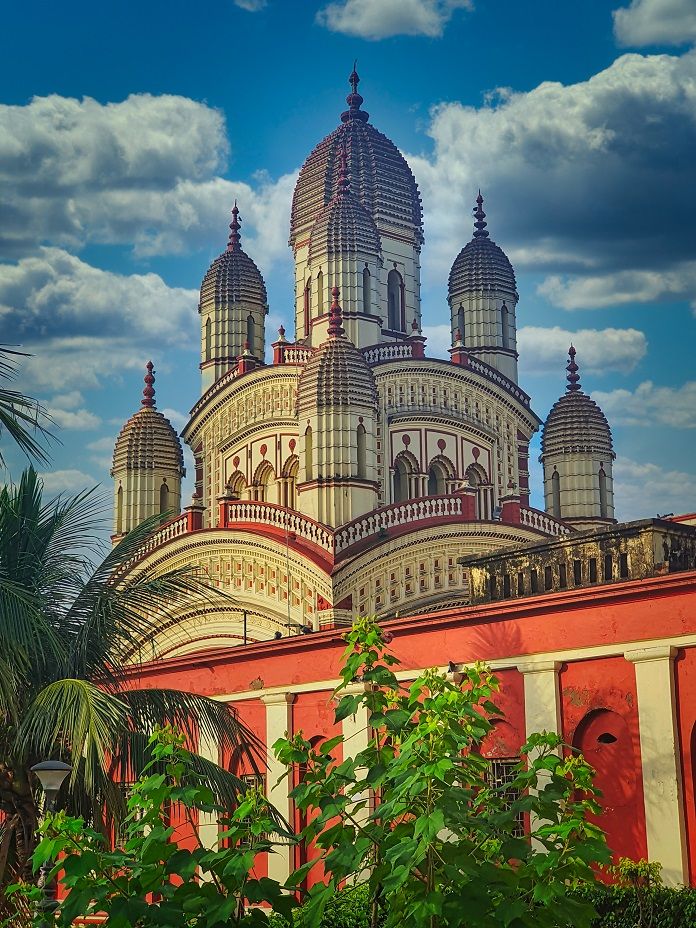 the top of a building with many domes on it's sides and palm trees in front