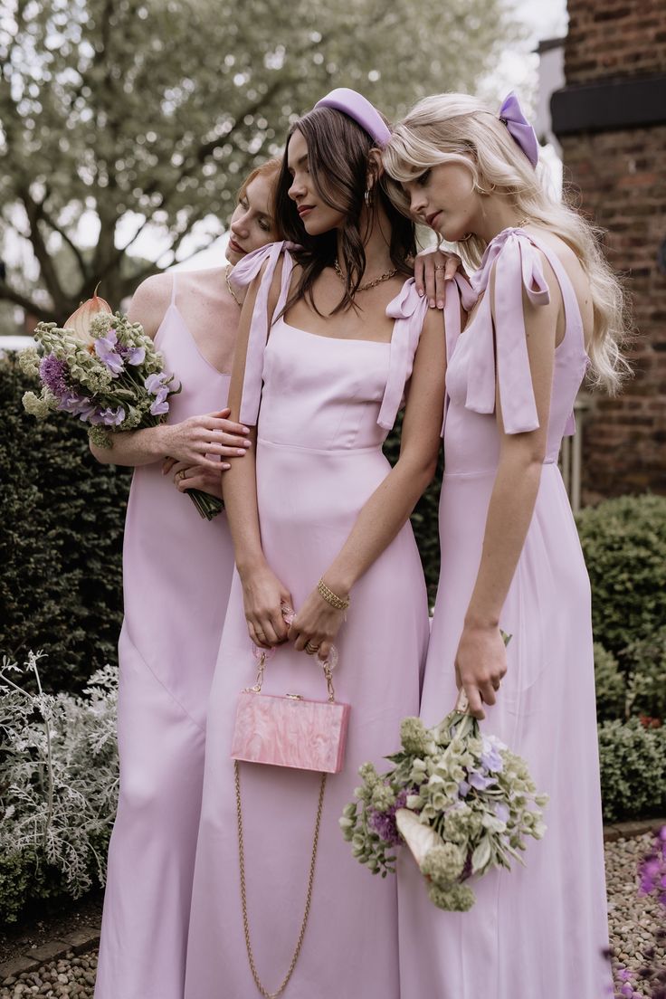 three women in pink dresses standing next to each other