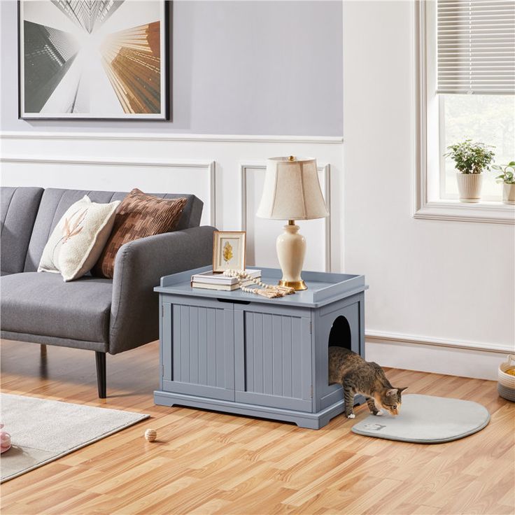 a living room with a couch, coffee table and cat bed