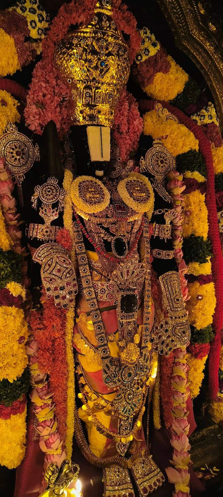 the statue is decorated with flowers and garlands