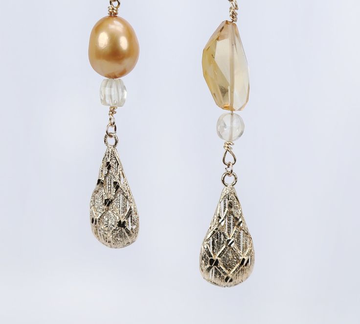 Asymmetrical, gold drop earrings begin with our vanilla beans, continue with citrine, layer on golden freshwater pearls, and end with intricately textured gold leaves. All gold is 14kt yellow. An approximate 4" drop. Gold High Luster Pearl Earrings For Evening, High Luster Gold Pearl Earrings For Evening, Gold Briolette Pearl Earrings, Gold Briolette Pearl Earrings For Formal Occasions, Elegant Drop Citrine Earrings, Citrine Drop Earrings For Wedding, Elegant Gold Citrine Earrings, Elegant Citrine Earrings For Wedding, Handmade Gold Briolette Pearl Earrings