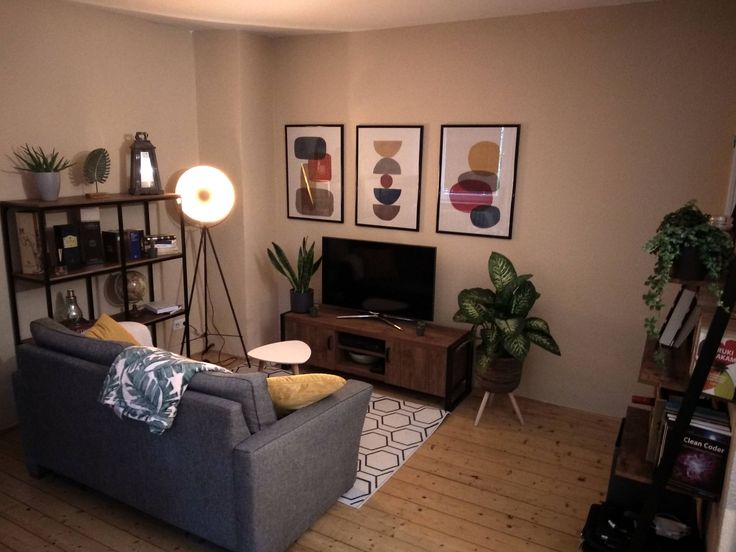 a living room filled with furniture and a flat screen tv sitting on top of a wooden floor