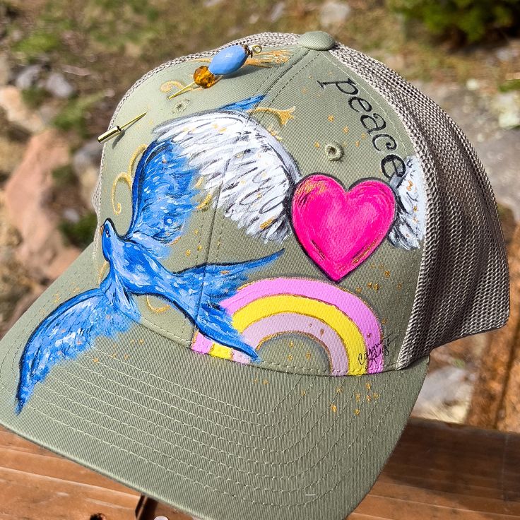 a trucker hat with an image of a bird and rainbows on the front