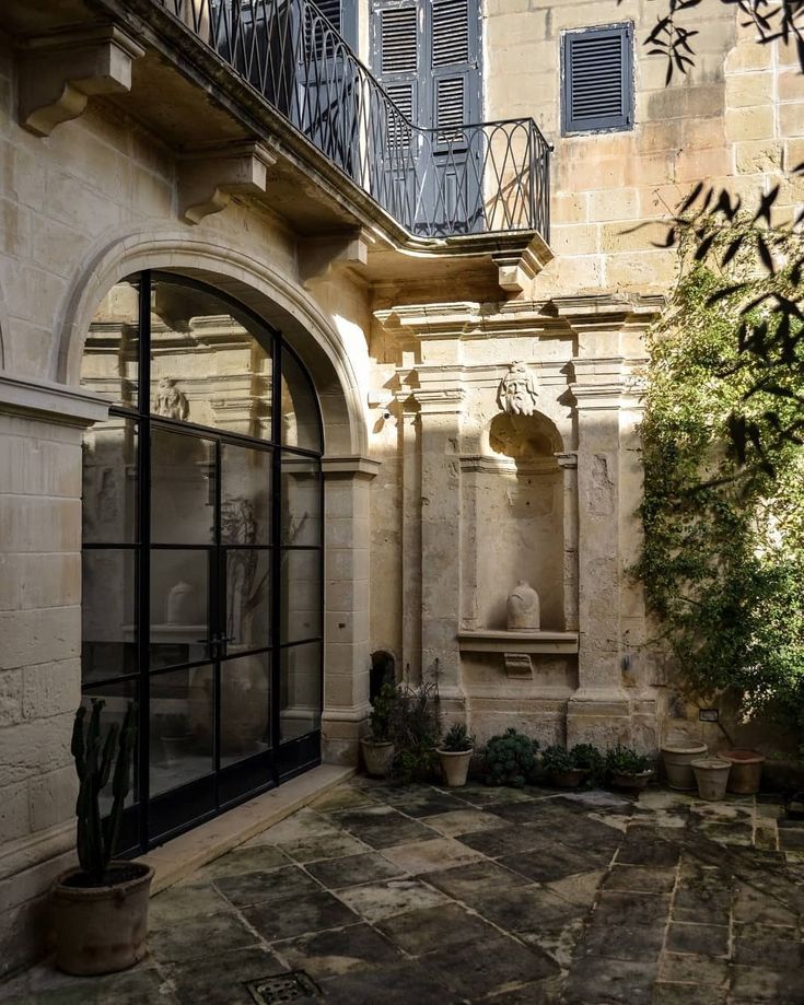 an outdoor courtyard with a fountain and potted plants