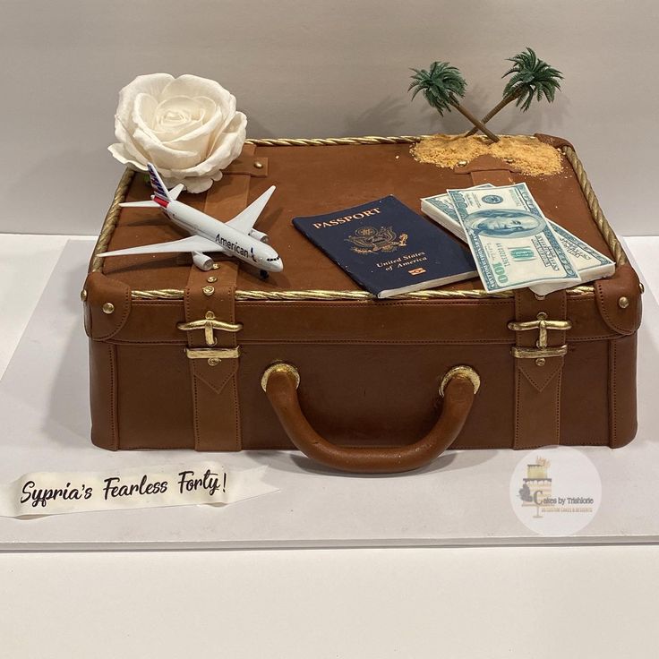 a cake made to look like an old suitcase with money and a rose on top