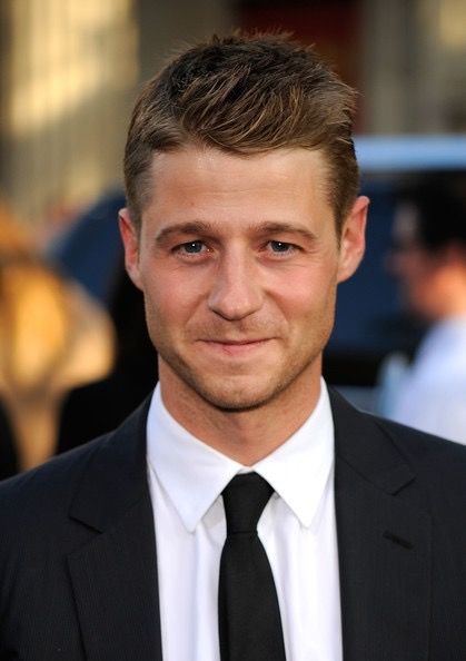 a man in a suit and tie smiling at the camera