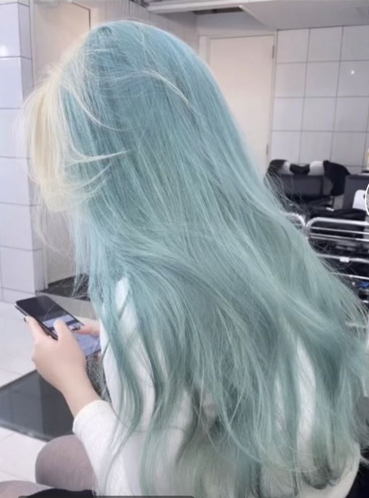 a woman with green hair using her cell phone