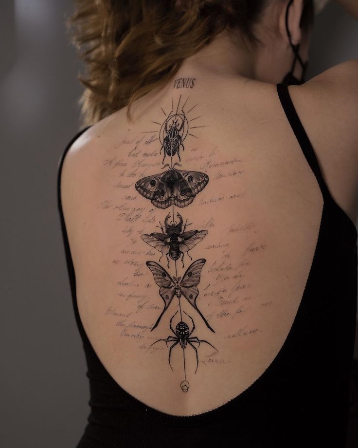 the back of a woman's shoulder with tattoos on it