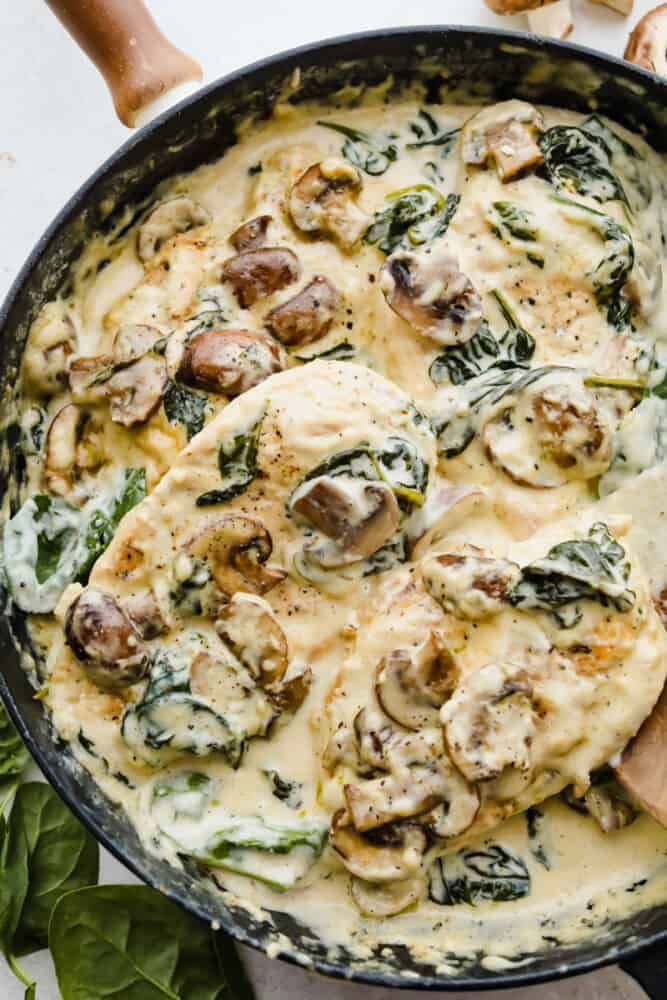 a skillet filled with spinach and mushrooms