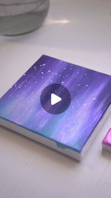 an open book sitting on top of a table next to a pink and purple object