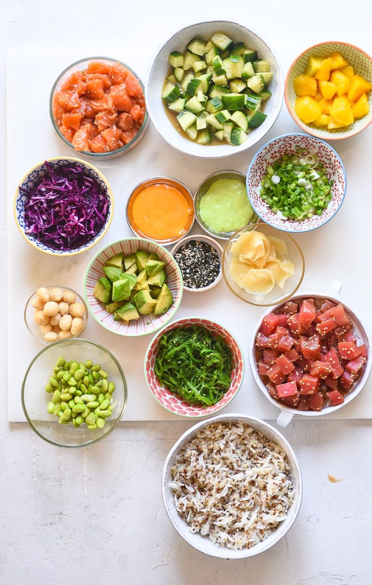 bowls filled with different types of food on top of a white countertop next to other dishes