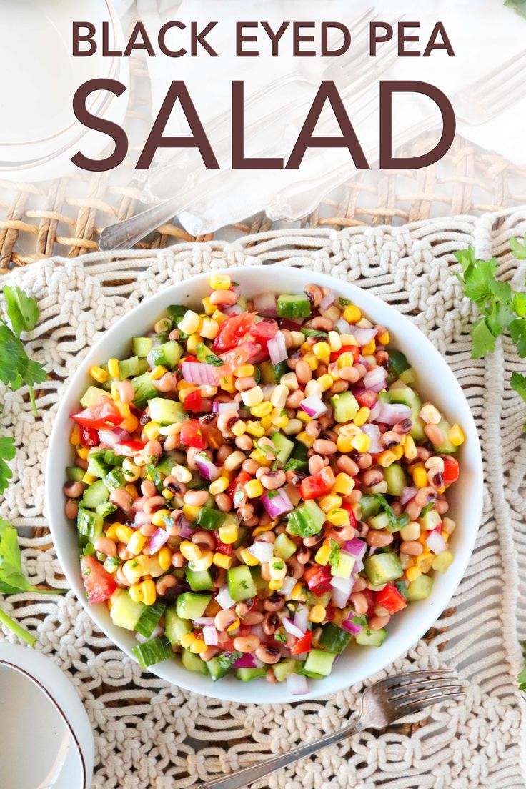 a white bowl filled with black eyed pea salad on top of a wicker place mat