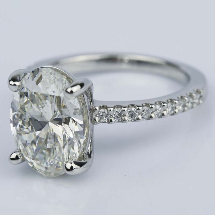 an oval cut diamond ring with pave set shoulders