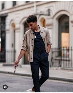 a man is walking down the street with an umbrella in his hand and shoes on