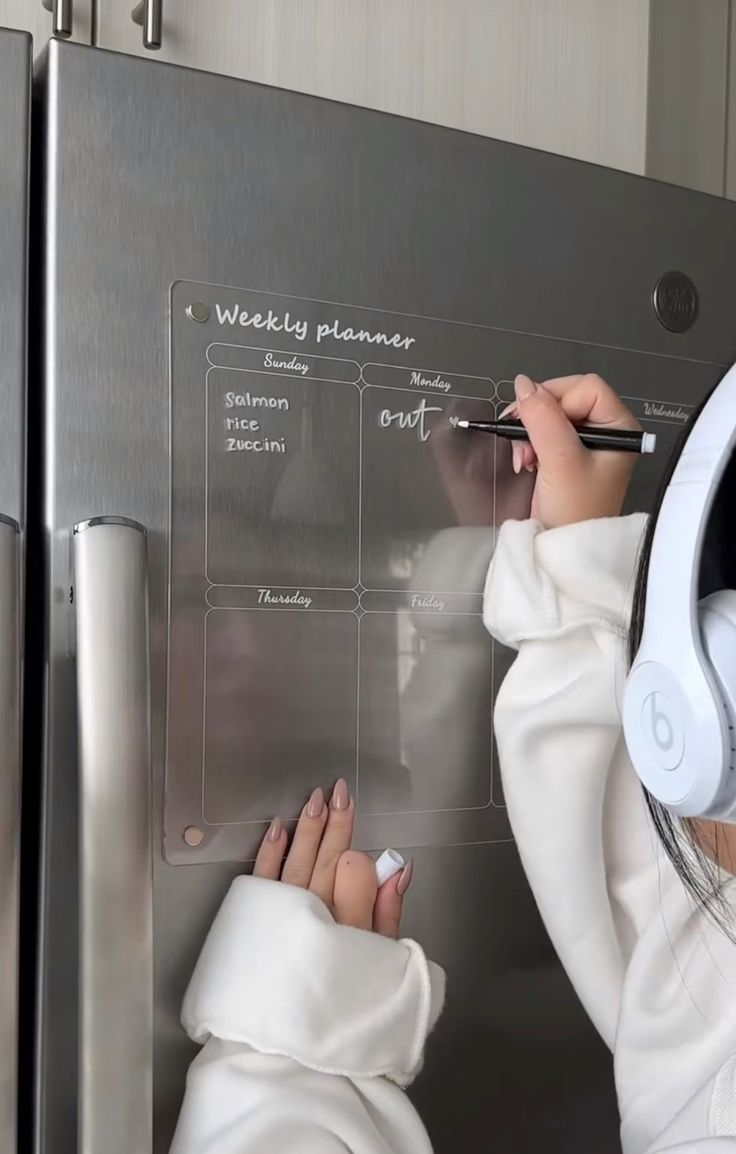 a woman writing on a dry erase board