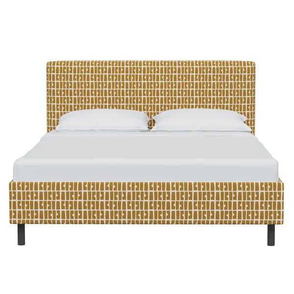 an upholstered bed with white sheets and yellow patterned headboard, made in the usa