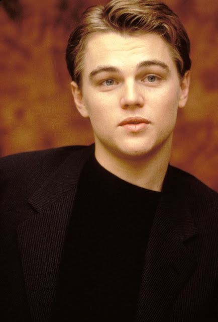 a young man in a black shirt and blazer