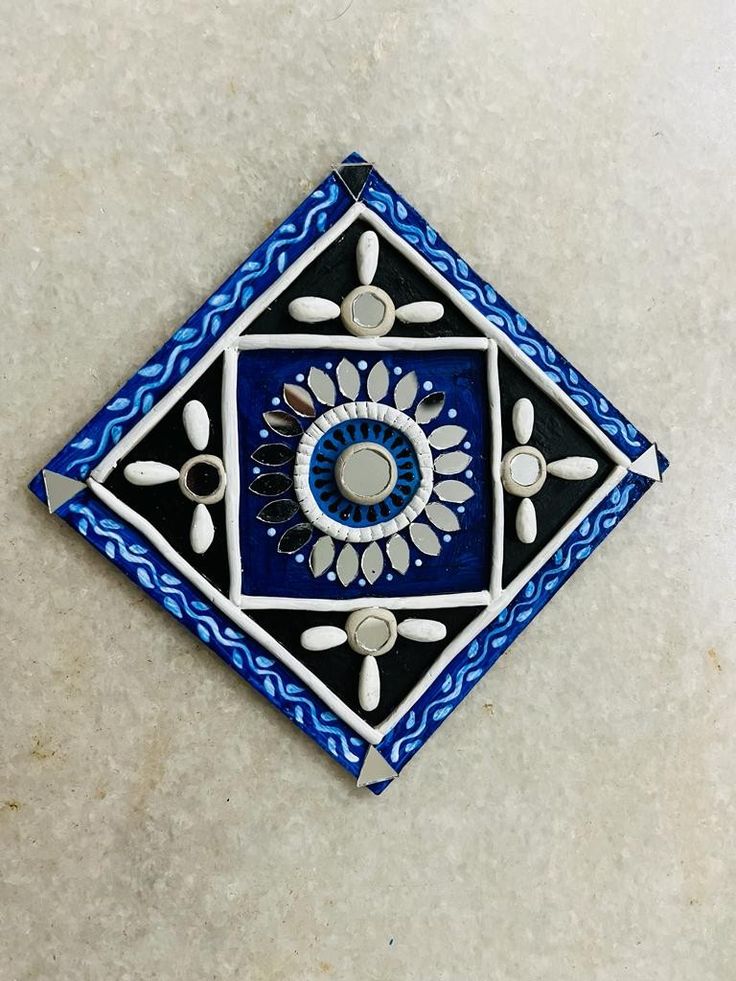 a blue and black tile design on the floor with white dots in the center, surrounded by smaller circles