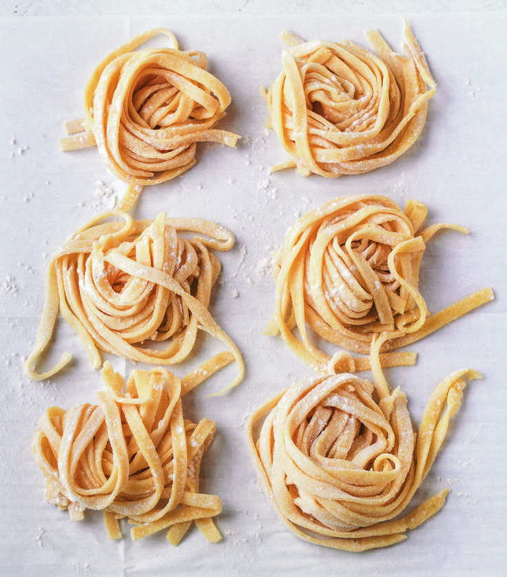 four uncooked pastas on a white surface, with one being cut in half