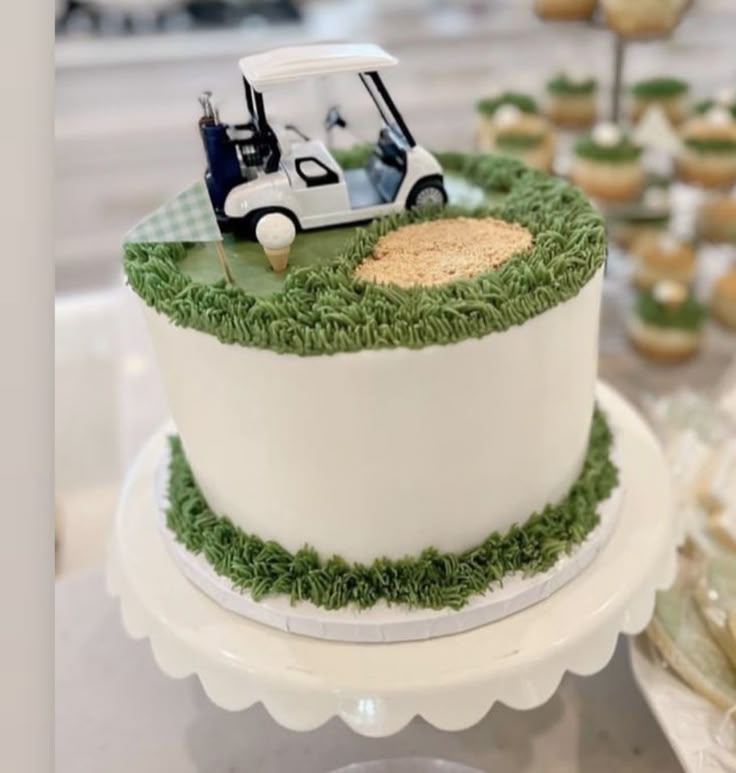 a golf themed cake on a table with cupcakes and desserts in the background