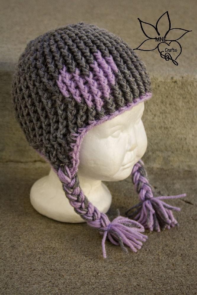 a white mannequin head wearing a gray and purple knitted hat with tassels