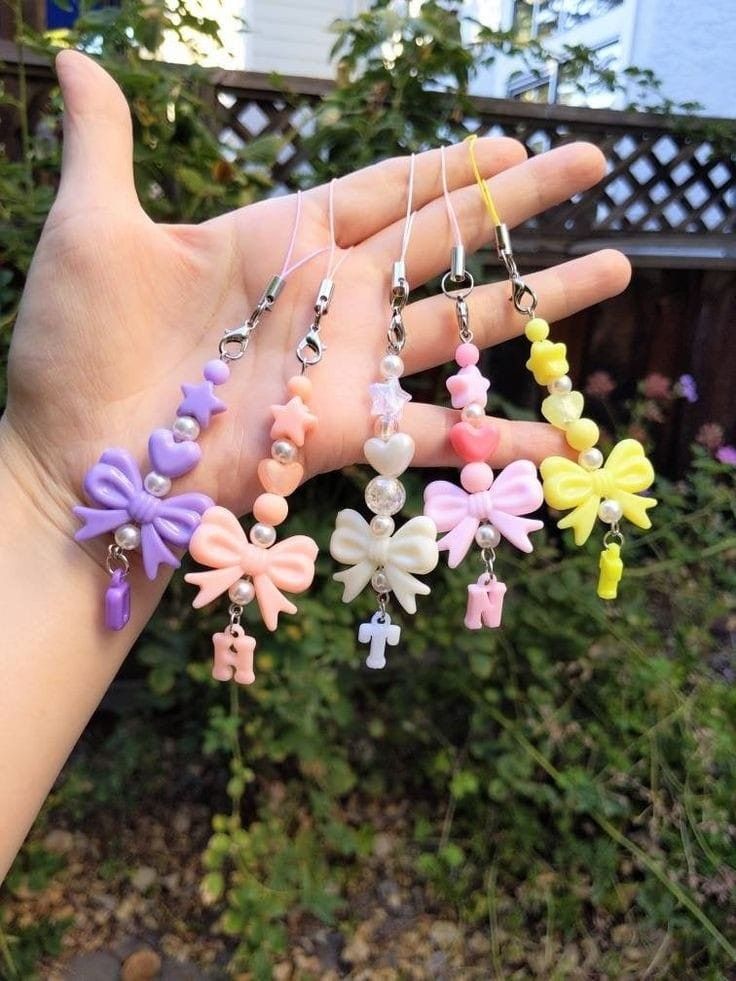 the hand is holding several small necklaces in it's palm, with flowers on them