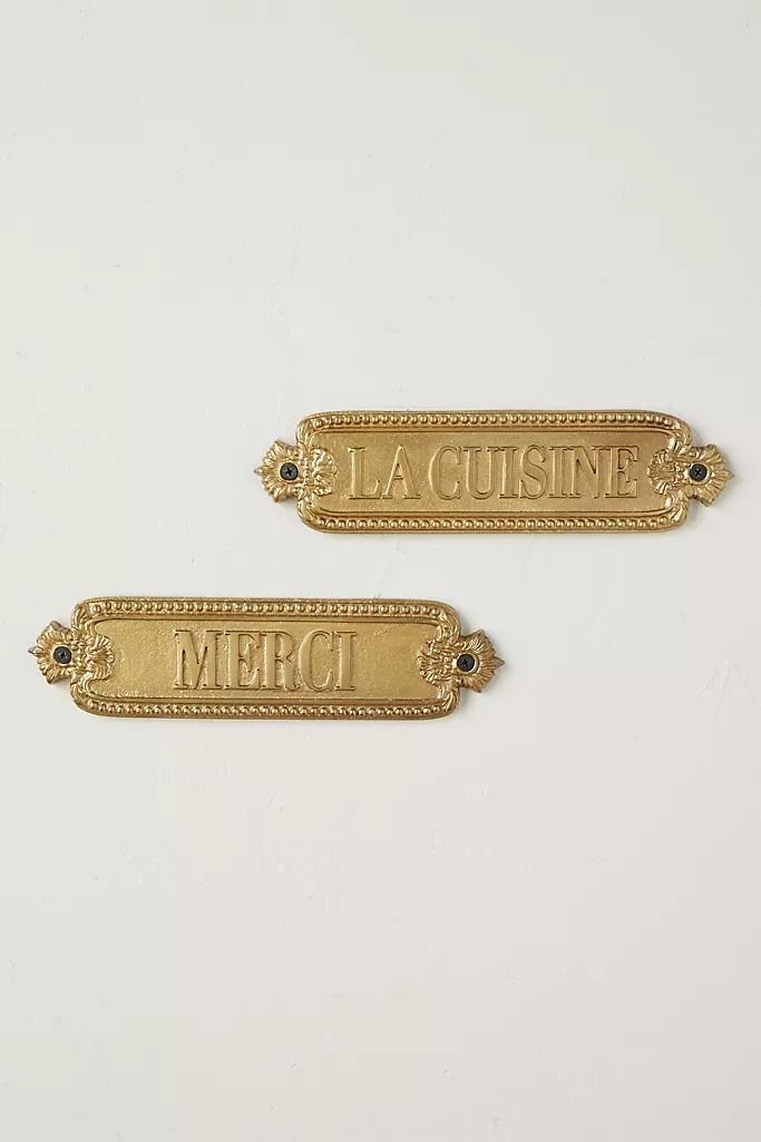 two gold - plated tags with the words la cuisinee and merci on them