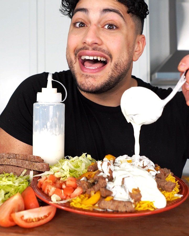 a man holding a spoon over a plate of food