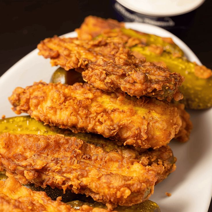 fried chicken and pickles on a white plate