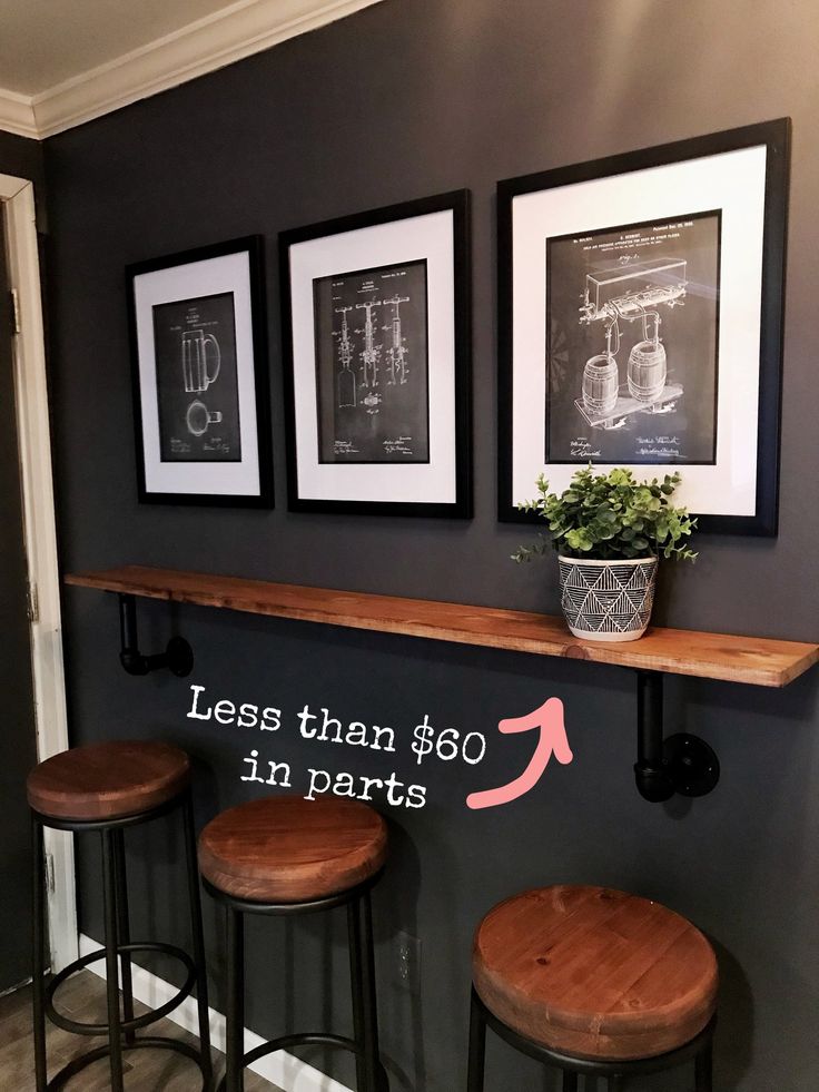 three framed pictures hang on the wall above bar stools