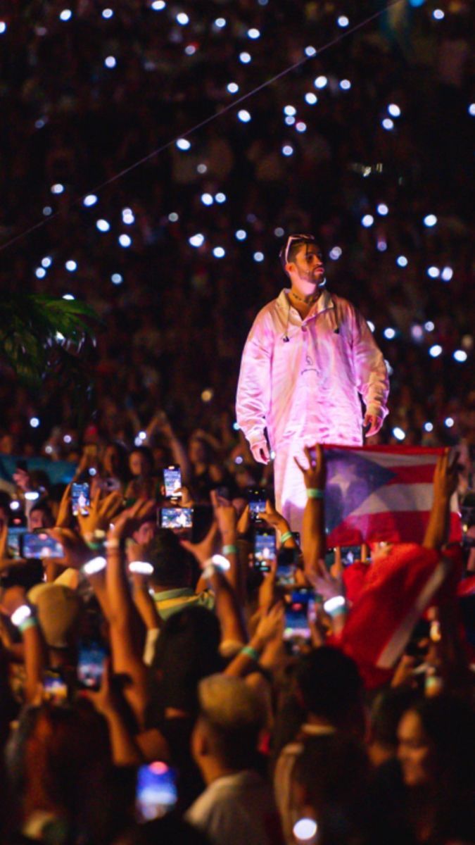 a man standing on top of a stage surrounded by people