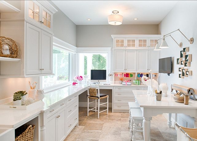 a kitchen with lots of white cabinets and counter top space in front of a window