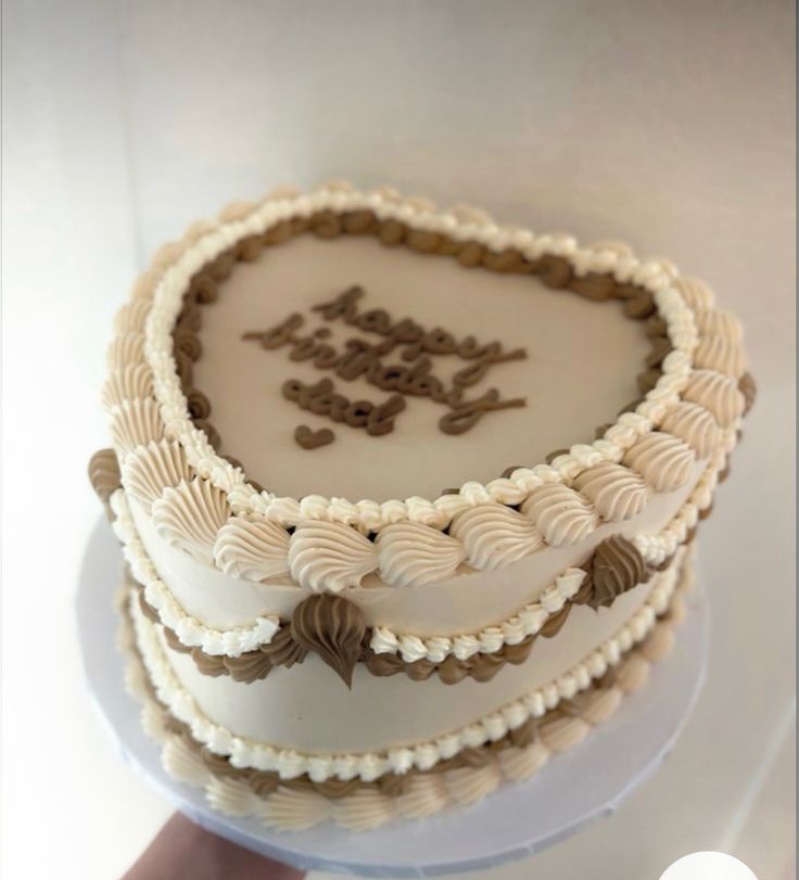 a three layer cake sitting on top of a white plate covered in frosted icing