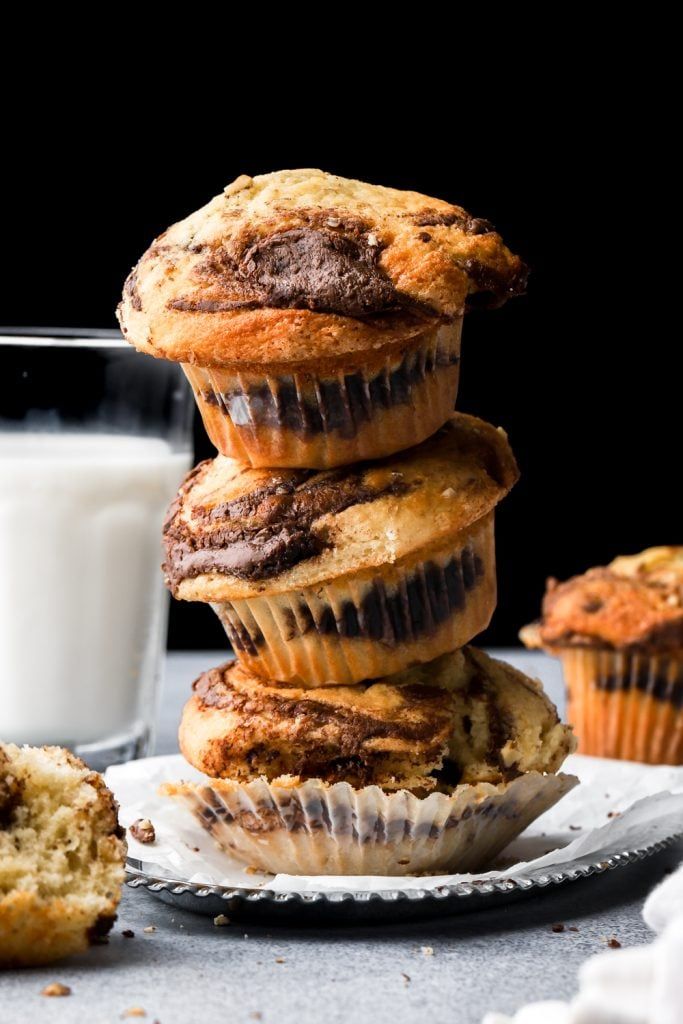 a stack of chocolate chip muffins next to a glass of milk