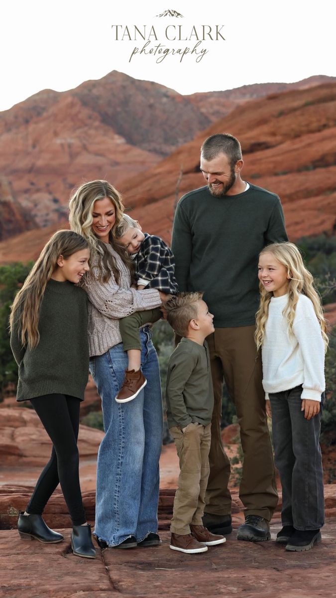 a family posing for a photo in front of red rock formations with the caption tan clark photography