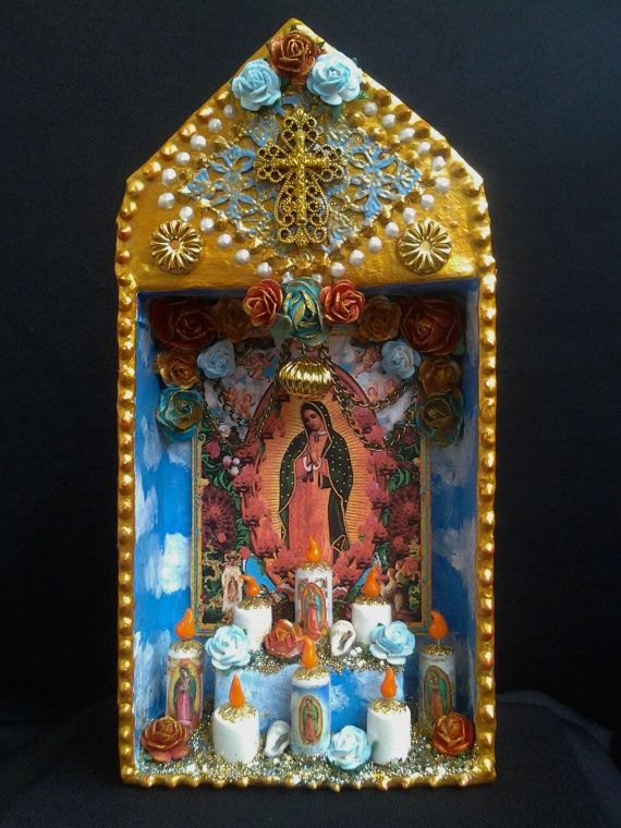 an image of the virgin mary surrounded by candles and flowers on a blue background with gold trimmings