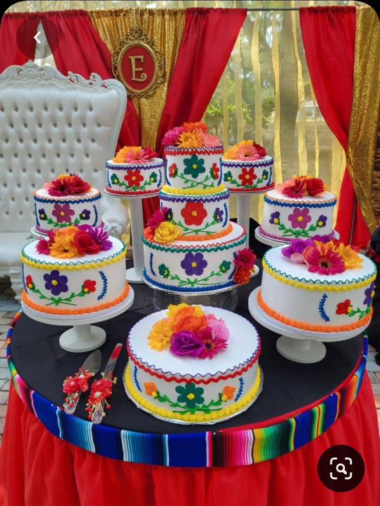 a table topped with lots of colorful cakes