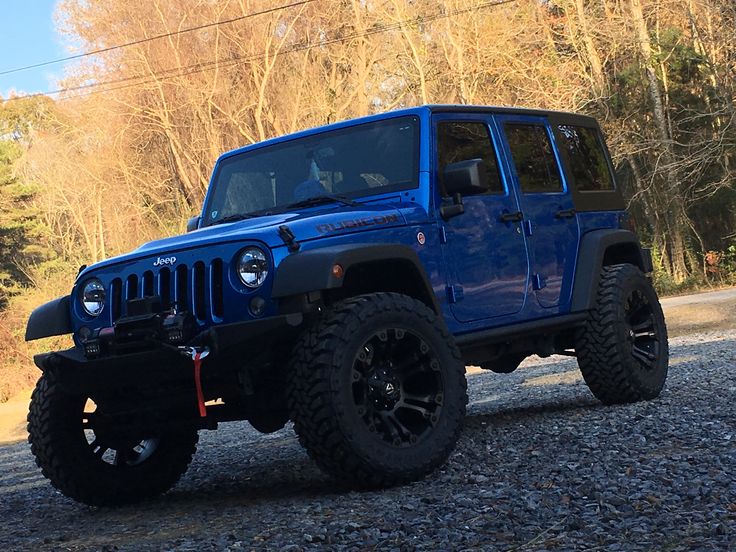 a blue jeep parked on the side of a road