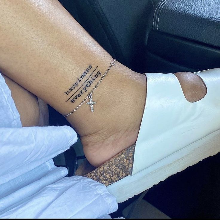 a woman's foot with a cross tattoo on her left ankle, sitting in a car