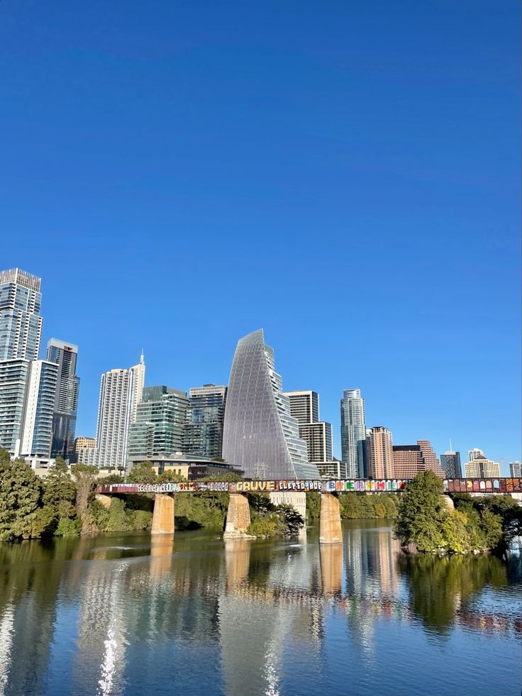 the city skyline is reflected in the water